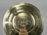 une image représentant une assiette en or posée sur un socle, sur fond gris