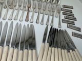 a lot of forks and knives laid out on the table