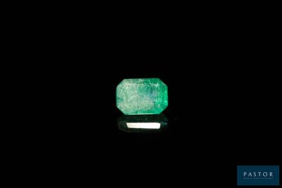 un gros plan d'une émeraude verte sur une surface noire
