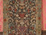 an antique rug hanging on a wall in a room