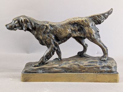 bronze statue of a dog on a wooden base on a white background