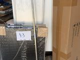 une boîte en carton sur laquelle est accrochée une pancarte, avec un balai posé devant