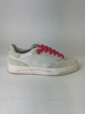 white and pink sneakers with pink laces on them on a white surface