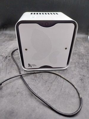 une petite enceinte blanche posée sur une table à côté d'une souris