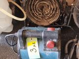 un petit ventilateur posé par terre à côté d'autres objets