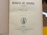 un livre ouvert posé sur une table, elle-même posée sur une autre table