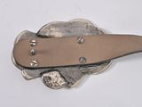 a silver plate with a leather belt on top of it