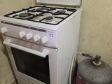 un poêle blanc et un bidon de gaz dans un coin de la pièce