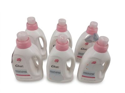 Quatre biberons de lait en poudre pour bébé sont alignés sur une surface blanche