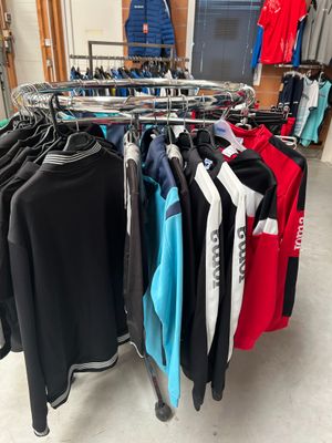 beaucoup de vêtements suspendus à une étagère dans un magasin