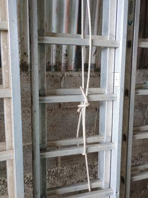 une échelle à laquelle est attachée une corde, dans une pièce