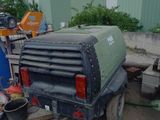 a truck that is sitting in the dirt near a building