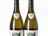 deux bouteilles de vin posées l'une à côté de l'autre sur une surface blanche