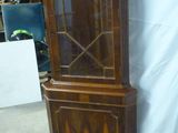une grande armoire en bois surmontée d'une porte vitrée