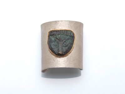 un gros plan d'une bague en argent sertie d'une pierre verte