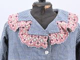 a picture of a blue and white checkered shirt with pink flowers on the collar