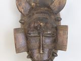 an image of a wooden mask with horns on it ' s head