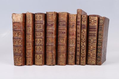 plusieurs vieux livres sont alignés sur une surface blanche