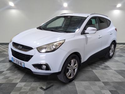 la voiture blanche est garée sur un sol en damier dans le garage
