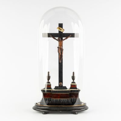 a statue of jesus on the cross under a glass dome