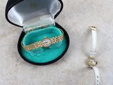 a watch and a bracelet in a box on the floor
