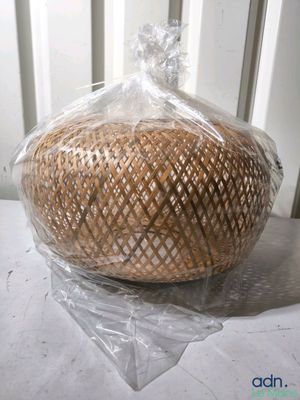 un panier de pain emballé dans du plastique posé sur une table
