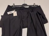 black pants hanging on a hanger on a white wall