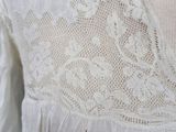 a close up of a woman ' s white blouse with lace on it