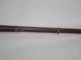 an old rifle with a wooden handle on a white surface
