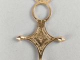 a close up of a gold cross on a white surface