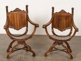 une paire de chaises anciennes en bois sculpté, montées sur des roulettes, posées sur un parquet