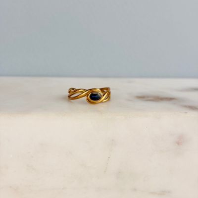 a close up of a gold ring on a marble surface
