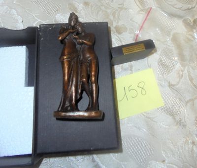 une statue en bronze représentant un homme et une femme, dans une boîte