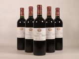 quatre bouteilles de vin rouge sont alignées sur une table