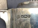 a silver tea pot with a handle on a table