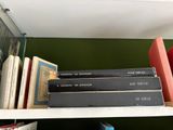 many books on a shelf in the corner of the room