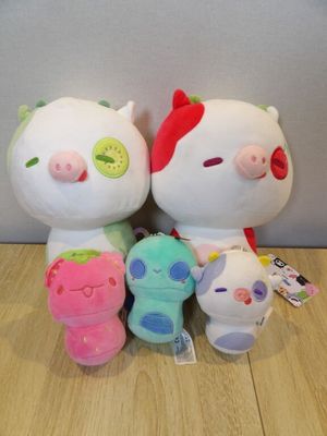 trois peluches assises les unes à côté des autres sur un plancher en bois