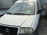 une petite camionnette blanche garée devant un bâtiment