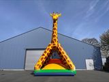 une grande girafe gonflable devant un immeuble