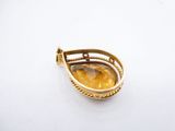 a close up of a yellow stone pendant on a white surface