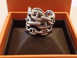 une image représentant une bague en argent dans une boîte, entourée d'une chaîne