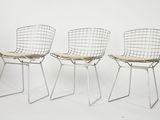 three chairs with a seat made of wire on a white background