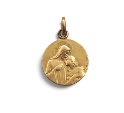 un gros plan d'une médaille d'or sur laquelle figure Jésus