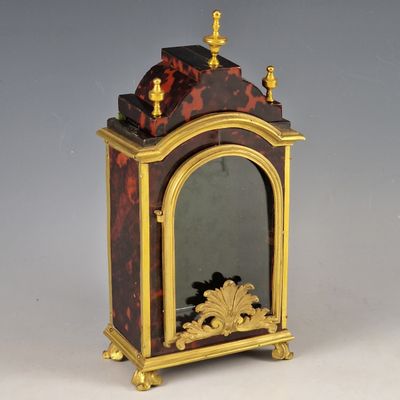 une petite horloge surmontée d'un miroir