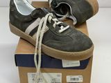 pair of grey sneakers with white laces sitting on top of a box