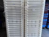two white plastic crates stacked on top of each other in a warehouse