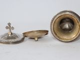 a silver object with a cross on top of it