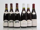 six bottles of wine are lined up in a row on a table