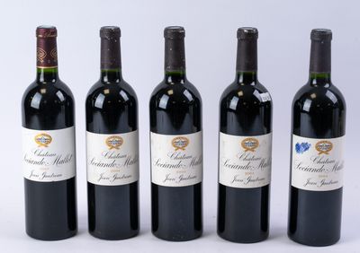 quatre bouteilles de vin rouge sont alignées