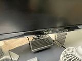 a computer monitor sitting on a desk with a fan